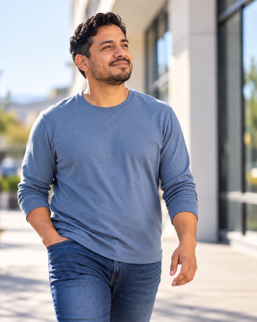 A man walking outdoors on a sunny day, looking relaxed